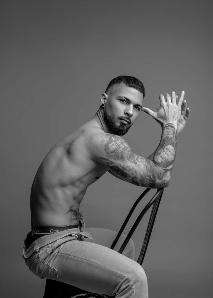 tattooed-male-model-sitting-on-chair-Male Strippers Arizona